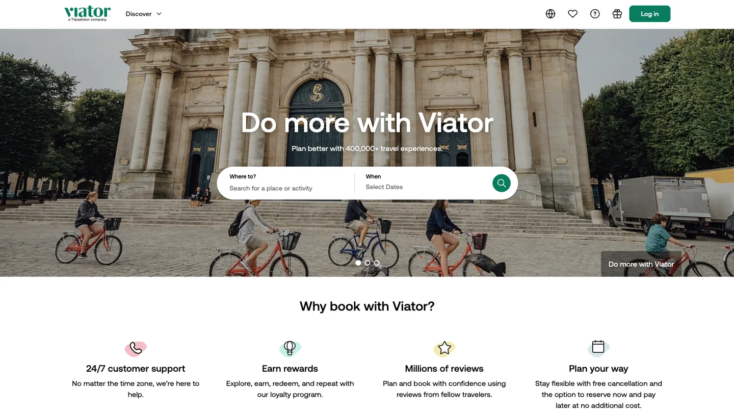 The Viator homepage, showing its search bar over a hero photo and a row of trust signals below